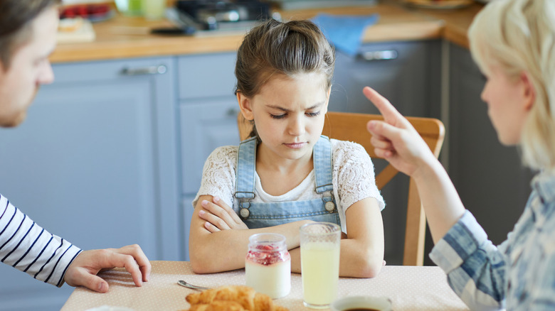 Child being scolded at the dinner table