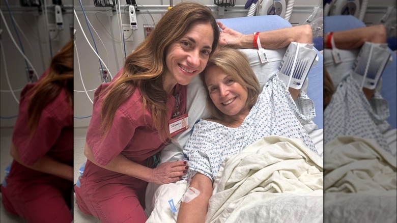 Katie Couric posing with her doctor while lying in a hospital bed