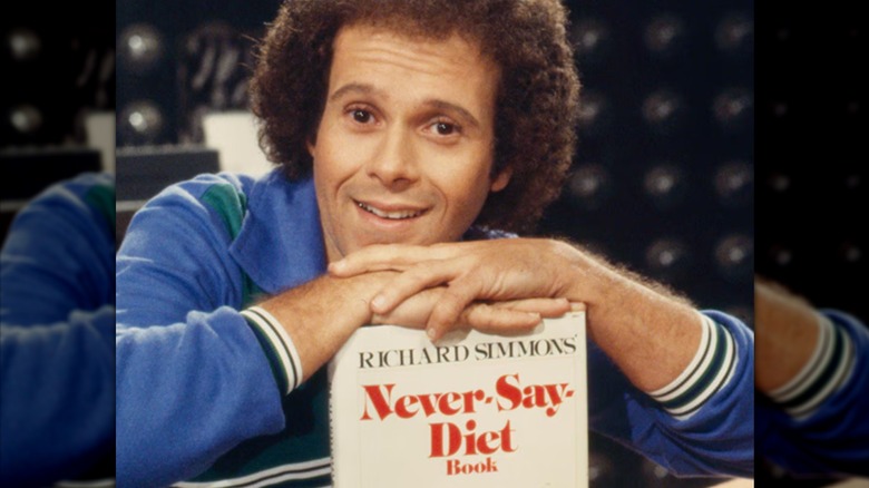 Richard Simmons posing with his cookbook
