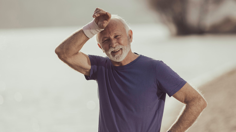 Elderly man wiping sweat off after a workout
