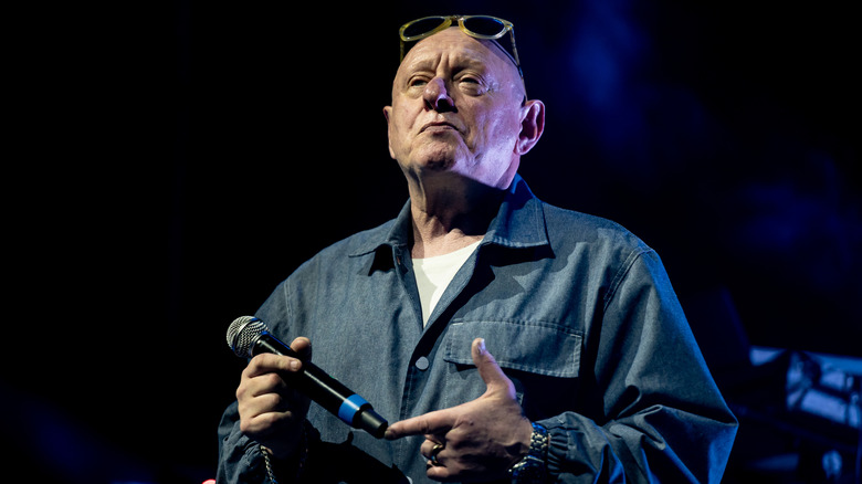 Shaun Ryder holding a microphone