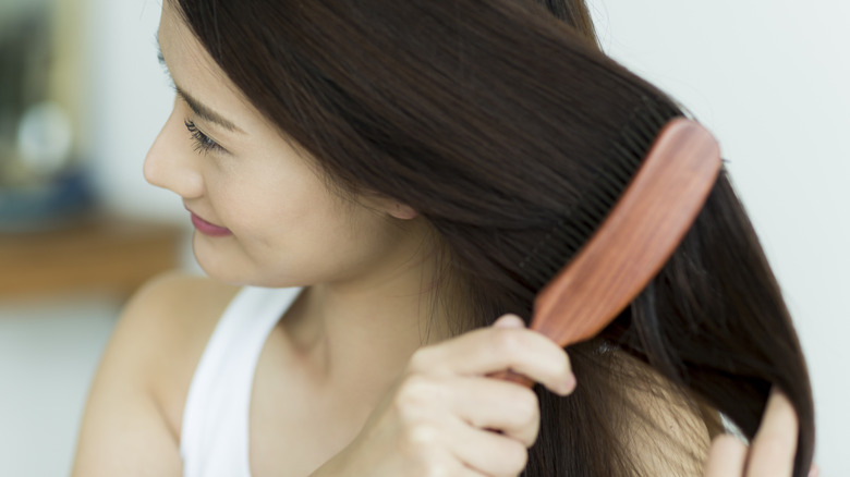 woman smiling and brushing her hair