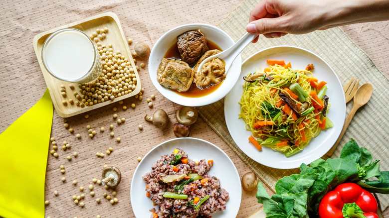 A hand scooping up vegetarian food out of a bowl