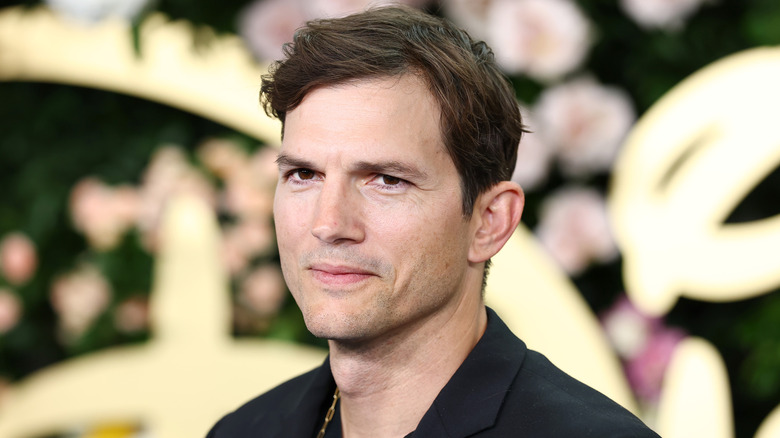 Ashton Kutcher poses in a black shirt for a publicity shot